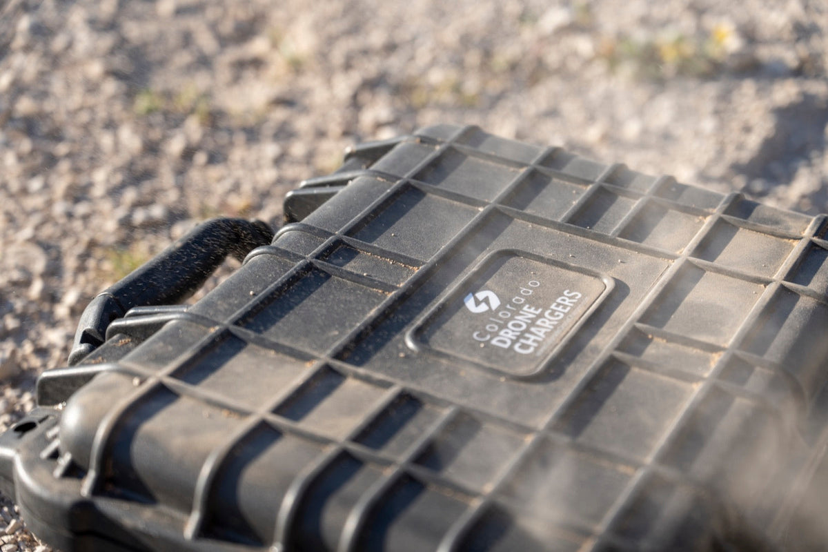 Dust-covered Colorado Drone Chargers PRCS rapid charger case on rocky ground after field use