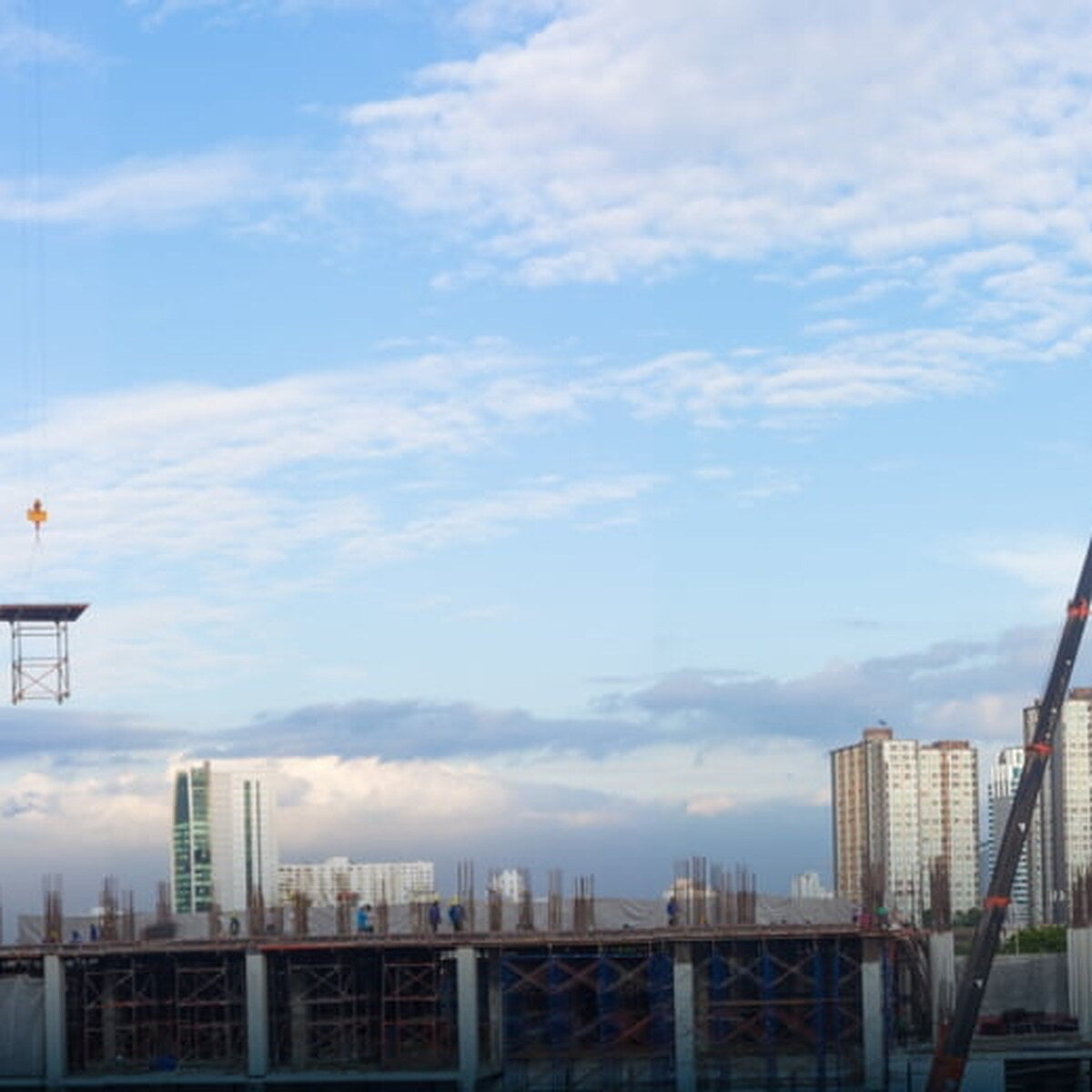 Active construction site with tower cranes and a partially built structure