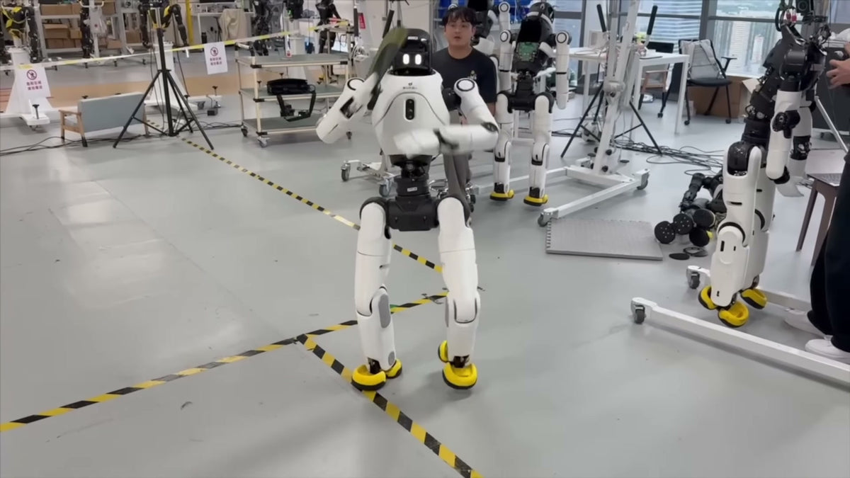 AgiBot X2 humanoid robot operating in a robotics research lab alongside engineers