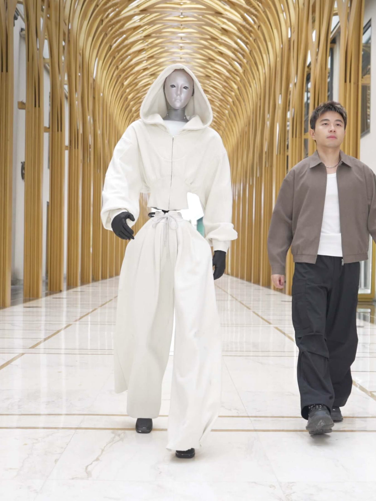 Unitree H2 humanoid robot walking beside a person indoors