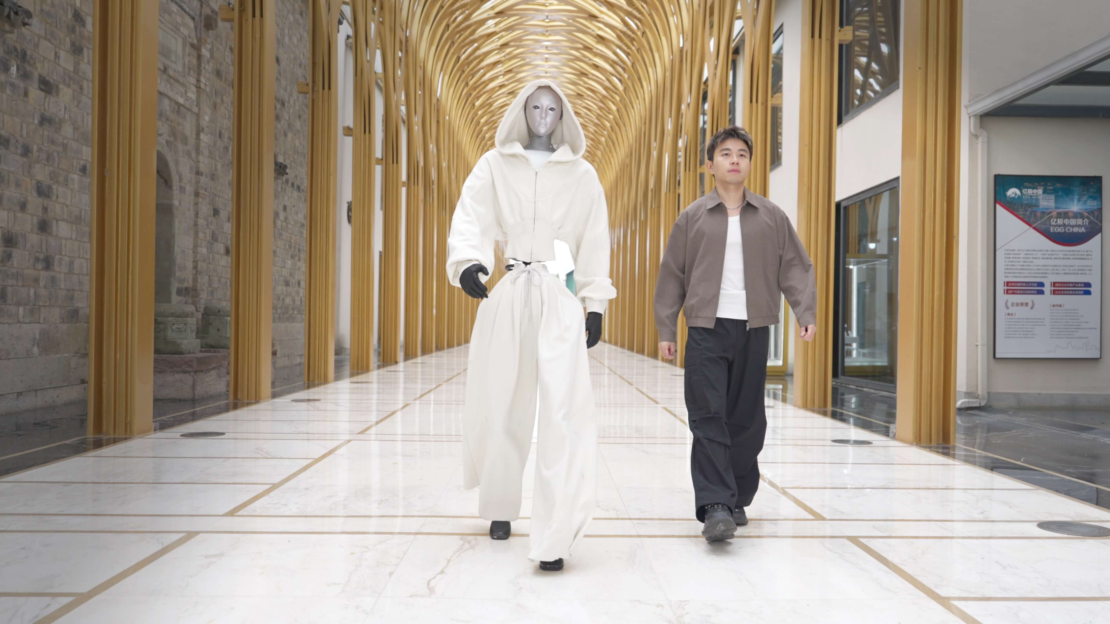 Unitree H2 Edu humanoid robot walking alongside a person