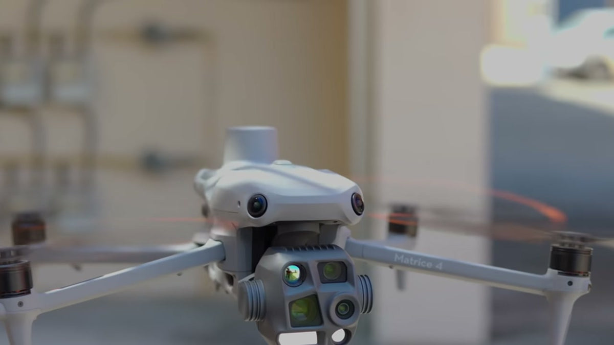 Close-up of a DJI Matrice 4T showing its thermal and telephoto camera gimbal