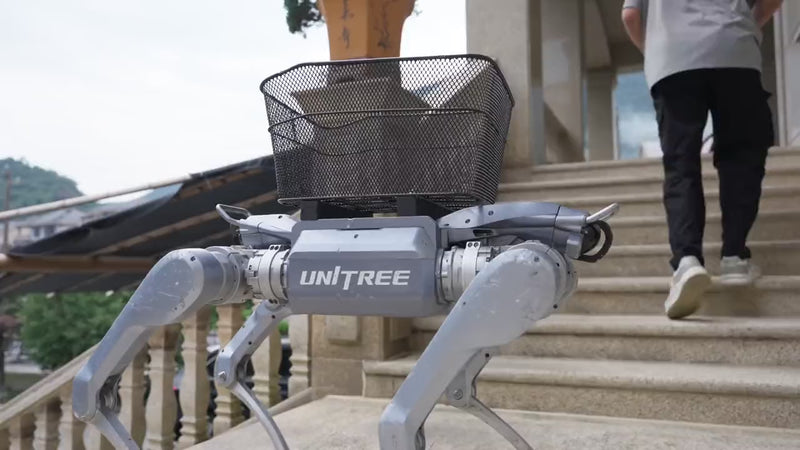 Unitree A2 quadruped robot carrying a payload up a hillside trail