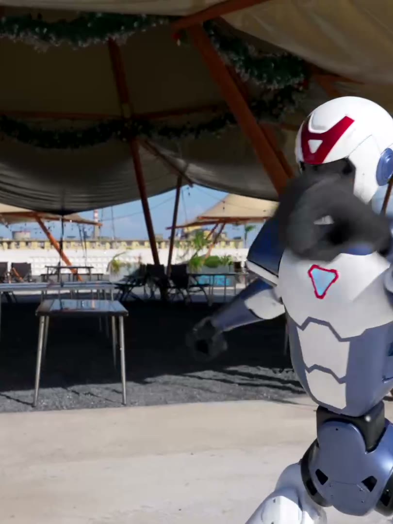 Unitree R1 humanoid robot throwing a kick outdoors